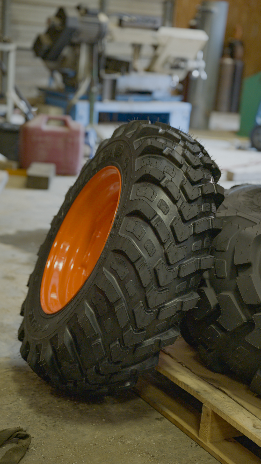 Tractor tires with orange rims inside the Robertson Equipment shop